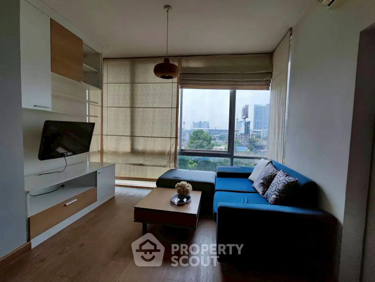 Modern living room with large window and stylish furniture, offering a cozy and inviting atmosphere.