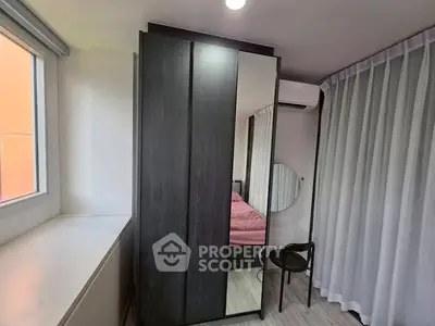 Modern bedroom with sleek wardrobe and large window for natural light