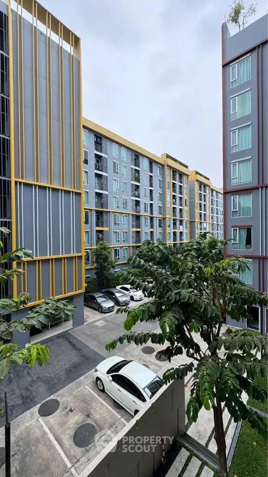 Modern apartment complex with parking and lush greenery