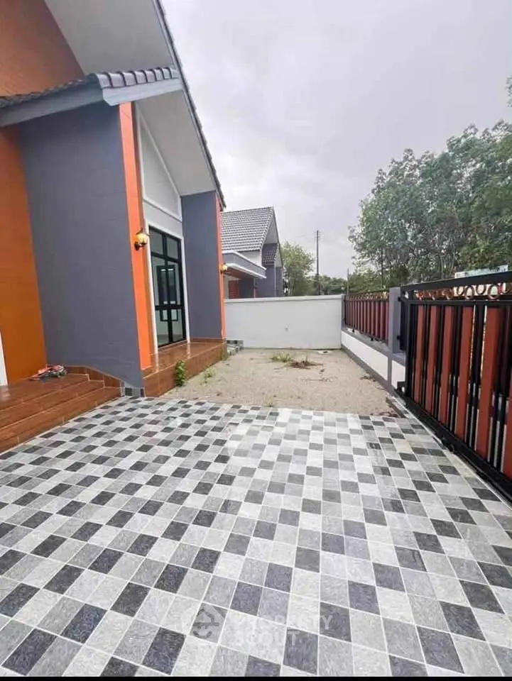 Modern home exterior with checkered driveway and sleek design.