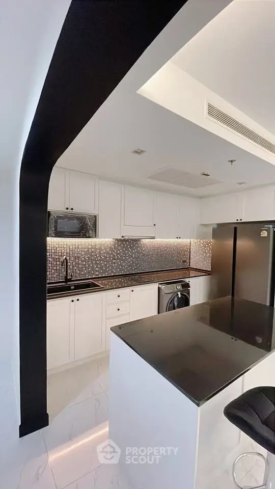 Modern kitchen with sleek black countertops and stylish backsplash