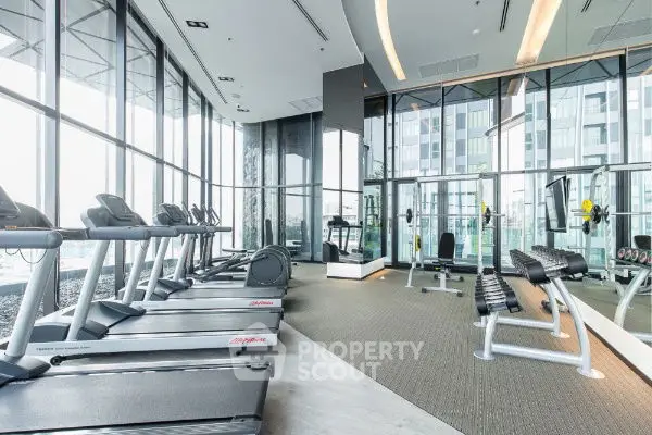 Spacious modern gym with panoramic city views and state-of-the-art fitness equipment.