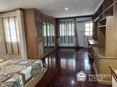 Spacious bedroom with wooden flooring and built-in wardrobe, perfect for comfort and style.