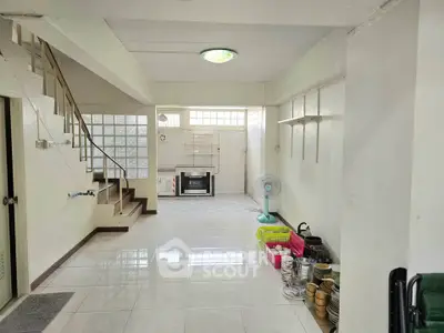 Spacious open-plan living area with staircase and tiled flooring, ideal for modern family living.