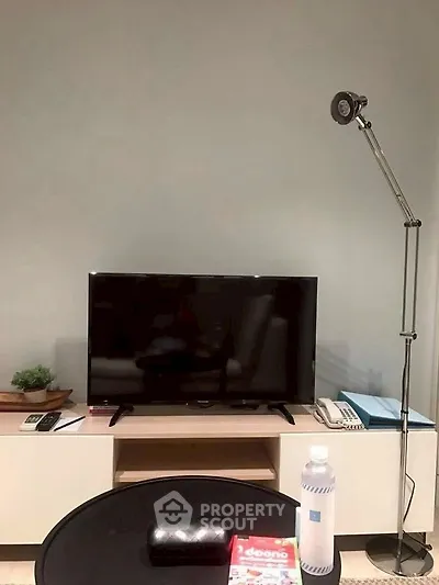 Modern living room with sleek TV setup and stylish floor lamp.