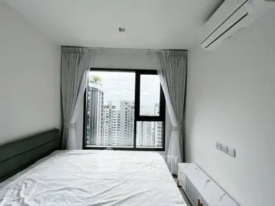 Modern bedroom with large window offering stunning city views, featuring sleek air conditioning and minimalist decor.
