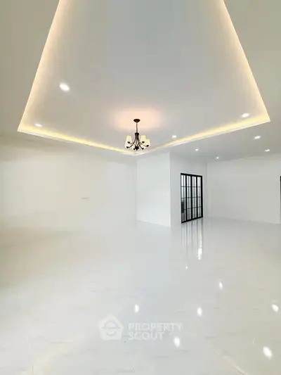 Spacious modern living room with elegant lighting and glossy white flooring