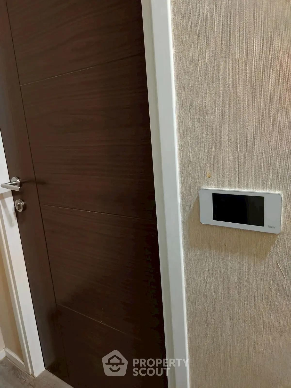 Modern interior door with smart thermostat on beige wall