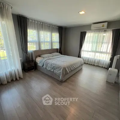 Spacious bedroom with large windows and modern decor
