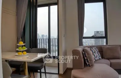 Modern living room with city view, cozy seating, and elegant dining area in a high-rise apartment.