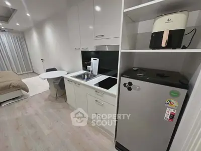 Modern studio apartment with compact kitchen and cozy bedroom area