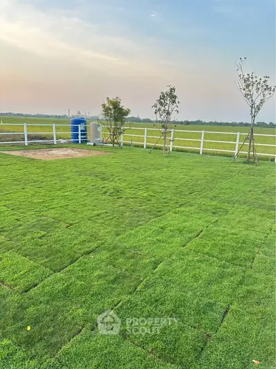 Expansive green lawn with scenic countryside view, perfect for outdoor activities and relaxation.
