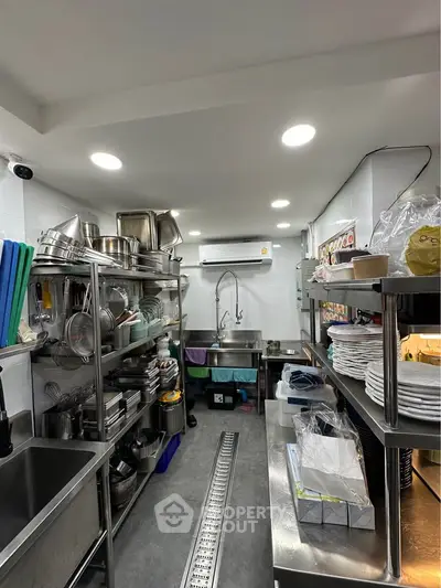 Spacious commercial kitchen with stainless steel shelves and modern appliances, ideal for culinary business.