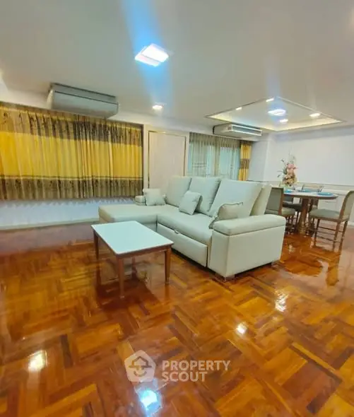 Spacious living room with elegant wooden flooring and modern furniture