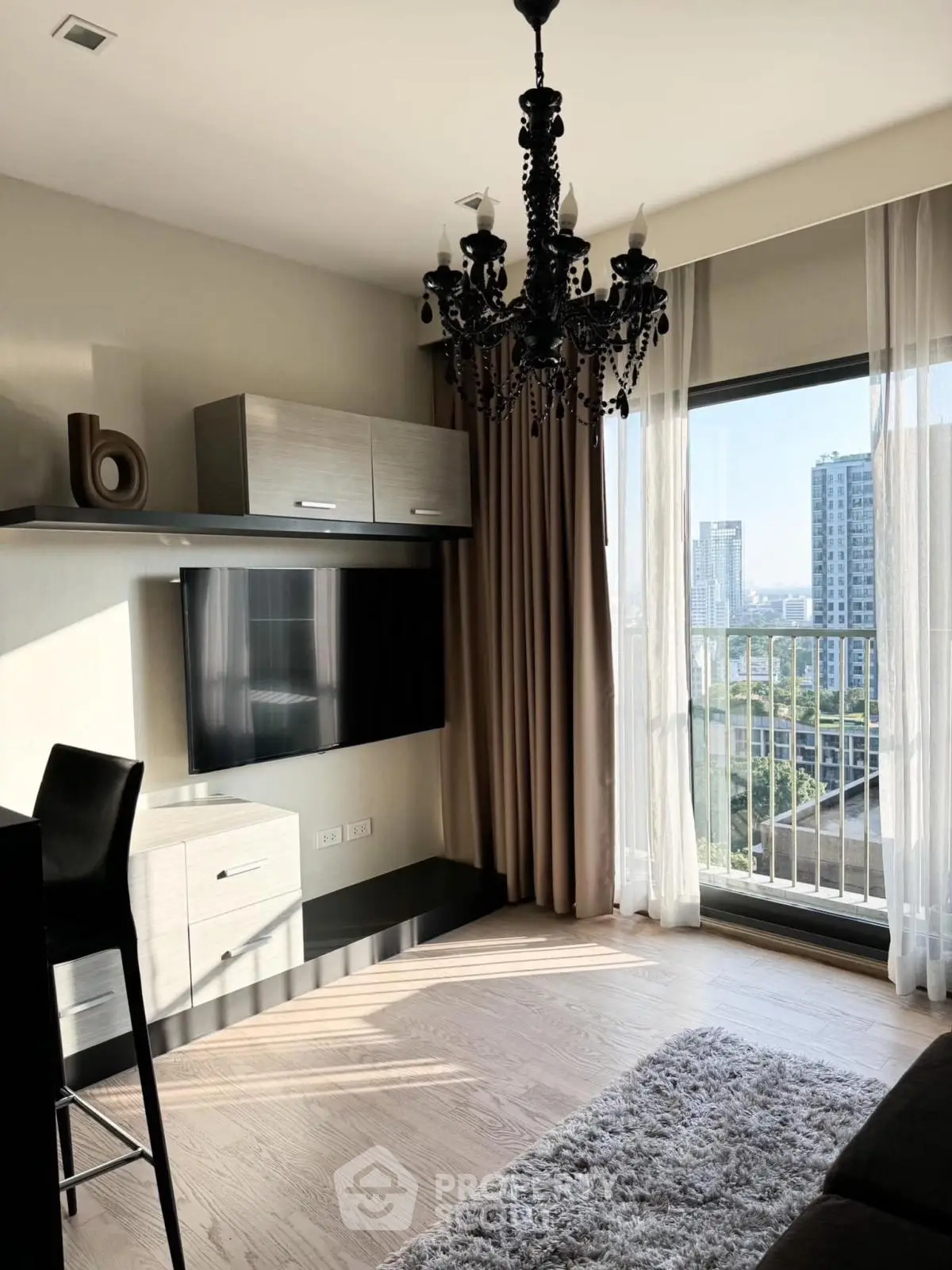 Stylish living room with chandelier and city view from large window