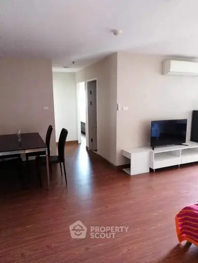 Spacious living room with modern furniture and wooden flooring in a stylish apartment.