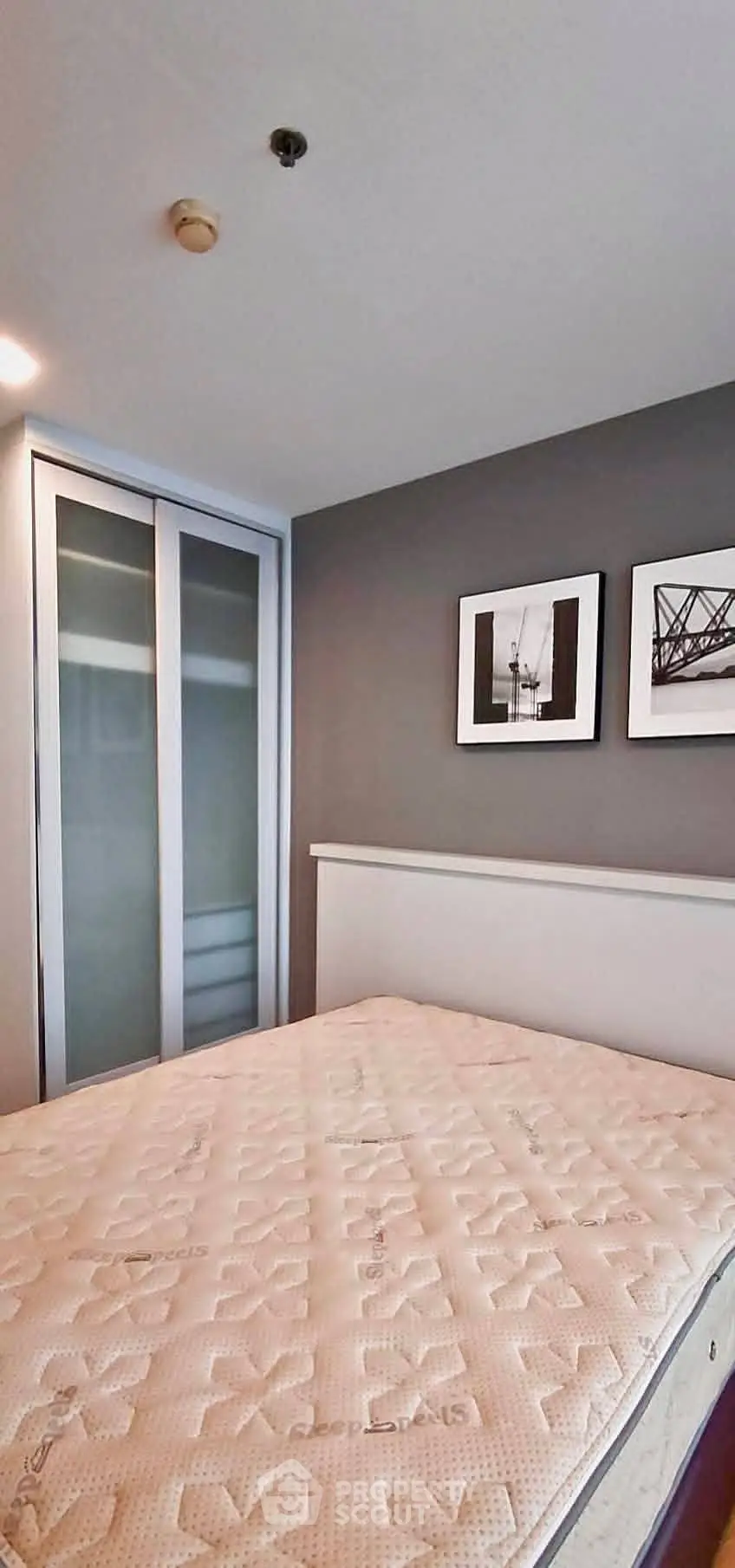Modern bedroom with stylish decor and sliding closet doors, perfect for urban living.