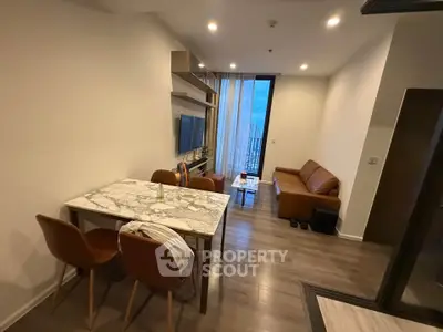 Modern living room with marble dining table and cozy seating area, featuring a large window with a view.