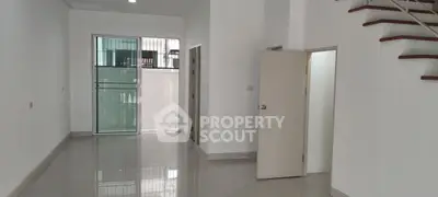 Spacious modern interior with tiled flooring and staircase, ideal for customization.