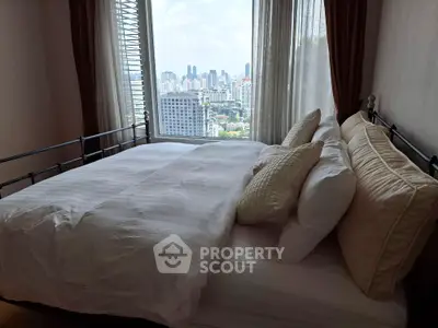 Luxurious bedroom with city view and elegant bedding in high-rise apartment