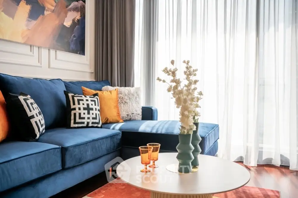 Stylish living room with blue sofa, modern decor, and natural light
