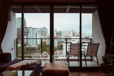 Stunning city view from modern balcony with cozy seating area.