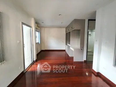 Spacious living room with wooden flooring and built-in storage