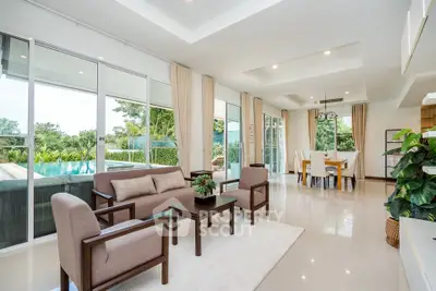 Luxurious open-plan living room with pool view and elegant dining area, perfect for modern living.