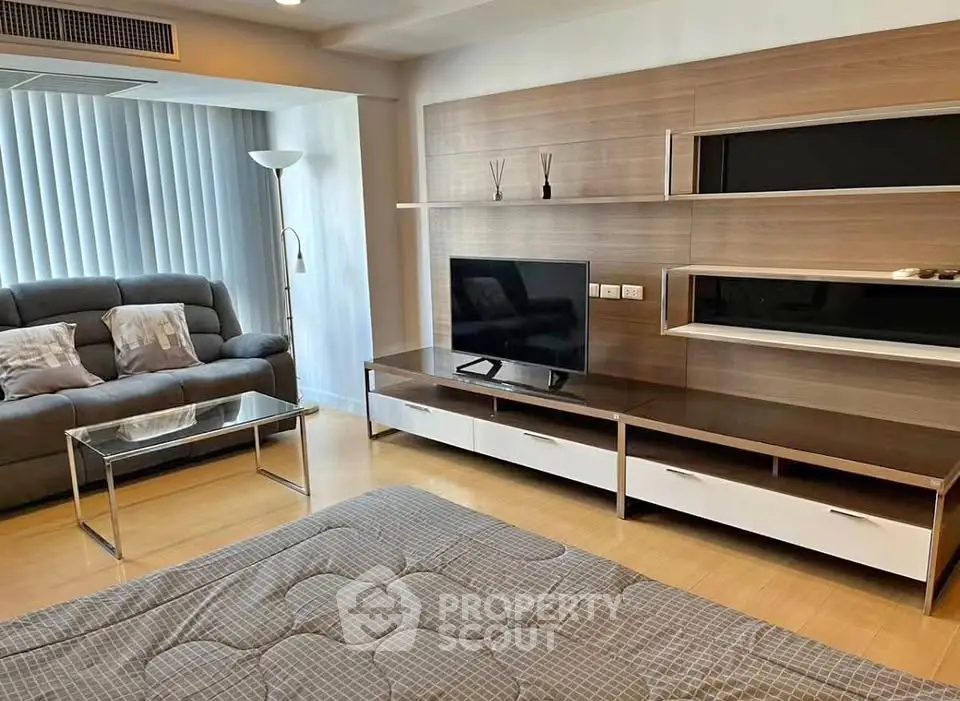 Modern living room with sleek entertainment center and cozy seating area.