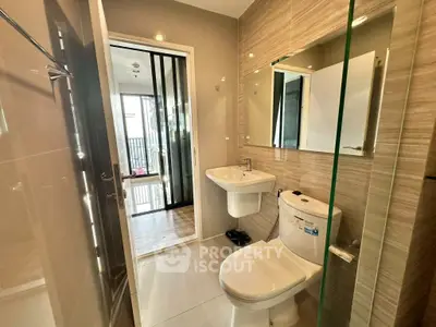 Modern bathroom with sleek fixtures and glass shower in contemporary apartment.