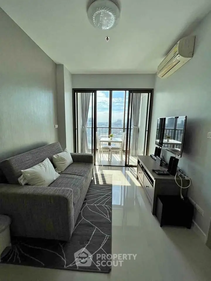 Modern living room with balcony and stunning view, featuring sleek furniture and natural light.