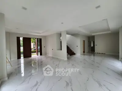 Spacious modern living room with marble flooring and staircase
