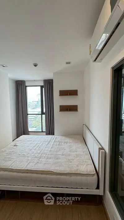 Modern bedroom with large window and minimalist decor in urban apartment