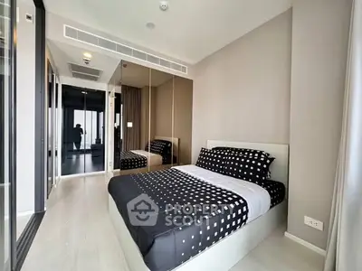 Modern bedroom with stylish decor and mirrored wardrobe in a contemporary apartment.