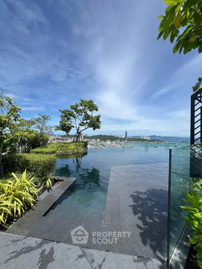 Luxurious rooftop infinity pool with stunning city and ocean views, surrounded by lush greenery.