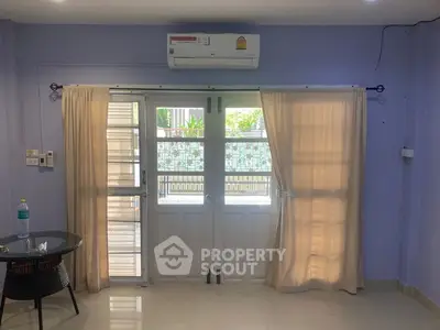 Spacious room with air conditioning and large windows for natural light.