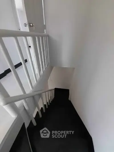 Modern staircase with sleek black and white design in a contemporary home.