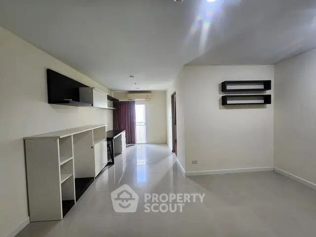Spacious modern living room with sleek shelving and bright natural light.