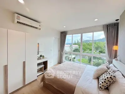 Bright and airy bedroom with large windows and scenic view, featuring modern decor and ample natural light.