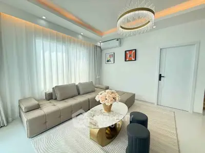 Elegant living room with modern sofa, chic chandelier, and stylish decor