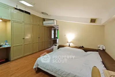 Spacious bedroom with cozy lighting and ample storage in modern apartment