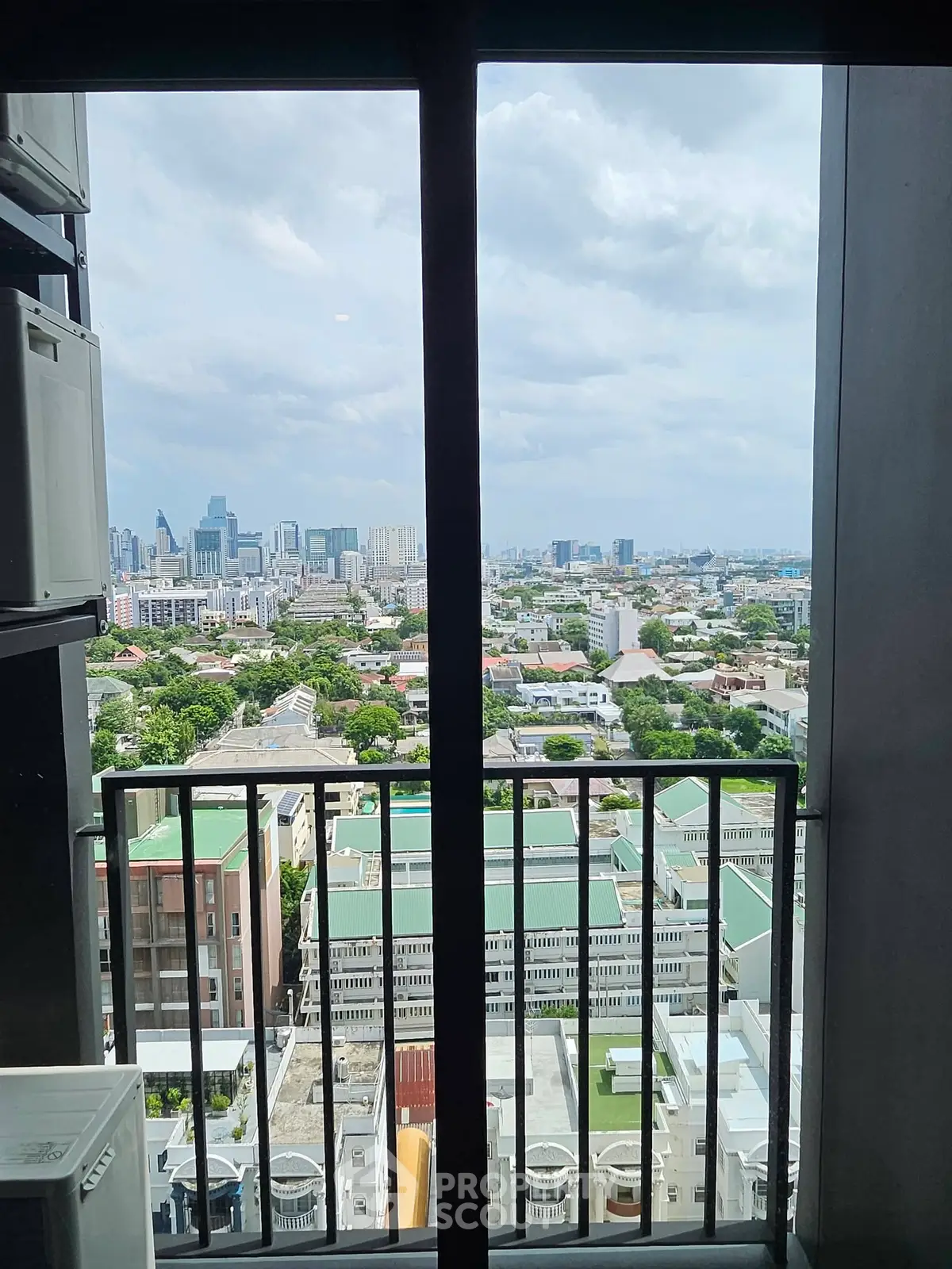 Stunning cityscape view from high-rise balcony with expansive skyline and lush greenery.