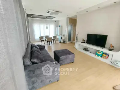 Spacious modern living room with plush gray sofa and stylish dining area