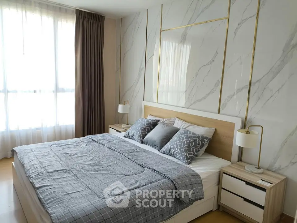 Luxurious bedroom with elegant marble accent wall and cozy bedding