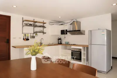 Modern kitchen with open layout, featuring stainless steel appliances and elegant dining area.