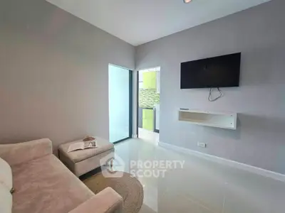 Modern living room with wall-mounted TV and cozy seating area