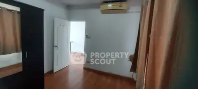 Cozy bedroom with wooden flooring and air conditioning unit