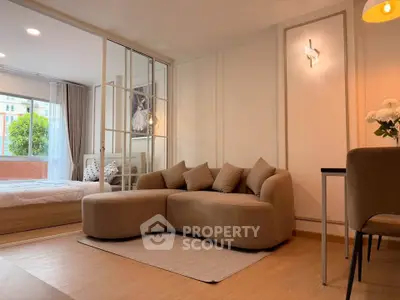 Modern living room with cozy sofa and bedroom view through glass partition