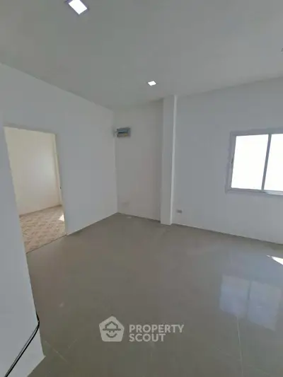 Spacious unfurnished room with tiled floor and natural light, ideal for customization.
