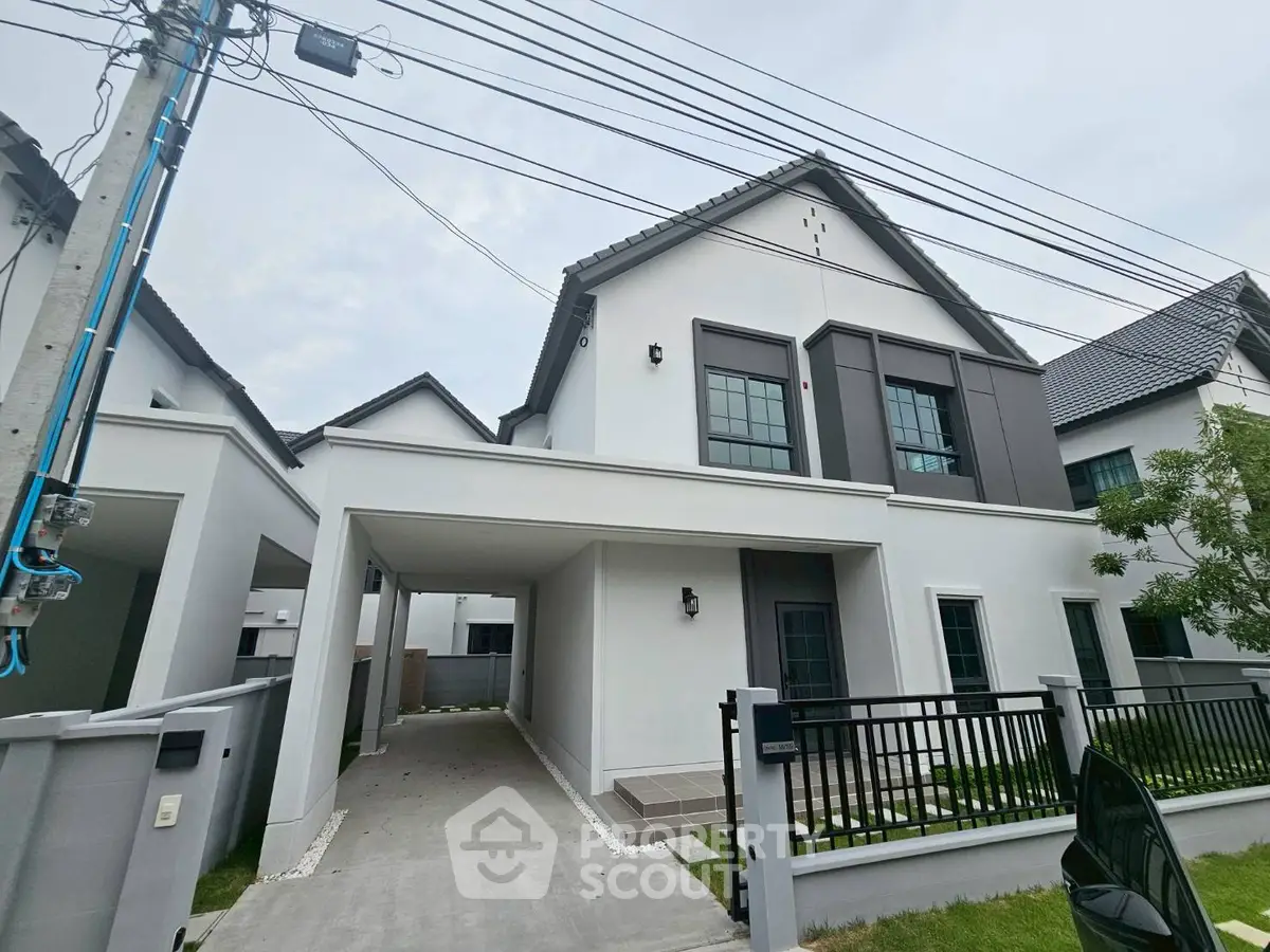 Modern two-story house with sleek design and spacious driveway in a serene neighborhood.